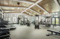 Spacious modern fitness center with high ceilings, large windows, and an array of state-of-the-art exercise equipment.