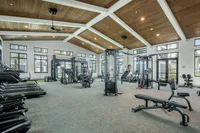Spacious and modern gym with high ceilings, filled with state-of-the-art fitness equipment and abundant natural light.