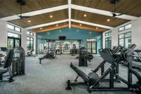 Modern fitness center with state-of-the-art equipment, high ceilings, and natural lighting for a vibrant workout experience.