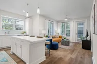 Inviting open-concept living space showcasing a modern kitchen with a breakfast bar, cozy seating area, and abundant natural light.