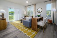 Contemporary living room with abundant natural light, featuring elegant wood furniture, vibrant yellow rug, and sliding glass doors leading to a serene outdoor view.