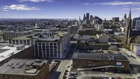 Breathtaking aerial view of a vibrant cityscape showcasing towering buildings, lively streets, and a picturesque skyline under a clear blue sky.