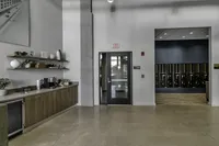 Modern apartment lobby featuring sleek storage solutions, bright lighting, and a welcoming coffee station.