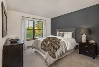 Inviting bedroom with a plush, stylish bed, elegant decor, and cozy ambiance, complemented by a wide window offering a refreshing view.