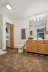 Elegant bathroom with modern lighting, spacious vanity, and wood accents, offering a luxurious feel.