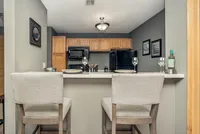 Inviting kitchen with modern cabinetry, elegant countertop dining for two, and stylish decor.