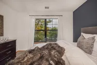Inviting bedroom with large window view, plush bedding, and elegant decor.