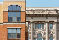 Stunning architectural contrast showcasing elegant brickwork next to intricate classical stone facade with detailed columns.