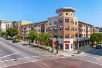 Charming urban apartment building with retail shops, stylish architecture, and convenient city location.