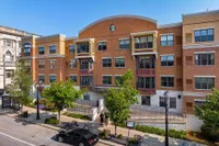 Charming urban apartment building with modern design, featuring large windows and attractive brick exterior, ideal for city living.