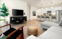 West Phoenix AZ Apartments - Meritum Sheely Farms - Living Room Featuring Vinyl Plank Flooring, Modern Light Fixtures, And Stylish Decor