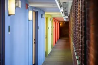 This colorful hallway features vibrant accent walls and contemporary lighting, creating a lively path to your front door. | Watch Factory Lofts | Watch Factory Lofts Apartments