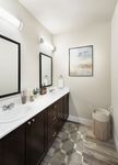 Modern bathroom interior featuring dual sinks, stylish mirrors, and contemporary décor.