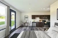 Stylish studio apartment with modern kitchen, dining area, and comfortable bed.