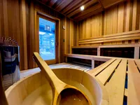 Inviting wooden sauna with warm lighting and wooden benches for relaxation.