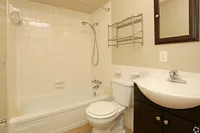 Inviting bathroom with a sleek white bathtub, modern amenities, and elegant storage solutions.
