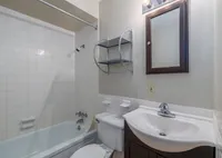 Bright and modern bathroom featuring sleek vanity, tiled walls, and inviting bathtub.
