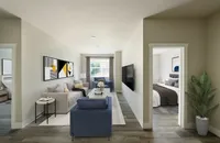 Modern apartment living room with stylish decor, featuring a cozy sofa, vibrant artwork, and a view into a chic, inviting bedroom.
