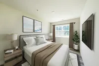Elegant bedroom with stylish decor, a cozy bed, and abundant natural light through a large window, creating a serene setting.