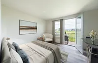 Inviting bedroom with elegant decor, large glass doors opening to a balcony with scenic views, and stylish furnishings for a relaxing retreat.