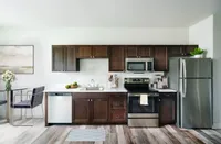 Modern kitchen with stainless steel appliances, elegant cabinetry, and a chic dining area with a floral centerpiece.