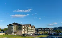 Charming apartment complex set against a clear blue sky, featuring modern architecture and scenic surroundings.