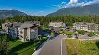 Charming apartment complex nestled amidst lush greenery with scenic mountain views, offering abundant parking and modern living in a serene environment.