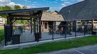 Charming outdoor communal area featuring a covered lounge, cozy seating, and string lights, perfect for social gatherings.