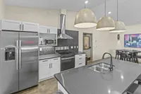 Modern kitchen with sleek stainless steel appliances, elegant pendant lighting, and a spacious island counter.