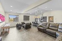 Modern open-concept living area with cozy seating, sleek kitchen, and large windows for natural light.