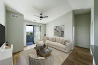Bright and modern living room featuring a plush beige sofa, sleek coffee table, and balcony access with a stunning view.
