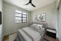 Inviting bedroom with contemporary decor, featuring a large window with scenic views, cozy bed, and stylish artwork.