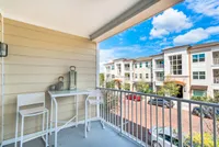 The Marq Highland Park Balcony View of Balcony, Showing Private Balcony, Street View, and Buildings in Background at The Marq Highland Park Apartments in Westchase Tampa