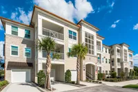 The Marq Highland Park in Westchase Tampa View of Building Exterior, Showing Garages, Landscaping, and Private Patio or Balconies at The Marq Highland Park Apartments