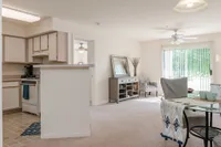 Living Room with Open-Concept Layout View of Furnished Living Room, Showing Bar Top, Dining Area, Carpet, Sliding Glass Door and Décor at Clearview Apartments
