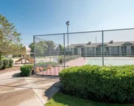 Tennis Court and Playground View of Sport Court, Showing Tennis Court, Bike Rack, and Adjacent Playground at Clearview Apartments