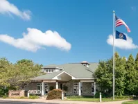 Exterior of Clearview's Clubhouse View of Leasing Center, Showing Building Entrance and Flag Pole Displaying the American Flag at Clearview Apartments