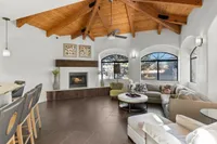 Inviting clubroom at Pavilions Apartments with vaulted wooden ceiling, cozy fireplace, and stylish seating area, perfect for relaxation.