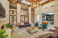 View of Resident Clubhouse with Fireplace, Ceiling Fan, and View of Community Kitchen at Raveneaux Apartments