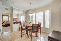 View of Dining Area with Hanging Light, Plank-Wood Flooring, and Décor at Raveneaux Apartments