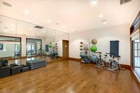 Marq Highland Yoga Studio View of Yoga Space, Showing Stationary Bicycles, Exercise Balls, Medicine Balls, and Yoga Mats at The Marq Highland Park Apartments in Westchase