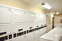 Modern laundry facility at Camelot in Yuma with abundant washers and dryers, bright lighting, and a welcoming atmosphere.