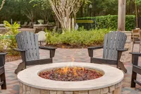 Inviting outdoor fire pit area with cozy Adirondack chairs, perfect for relaxing evenings at Raveneaux Apartments in North Houston.