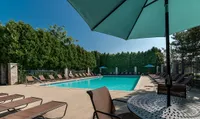 Pool and Sundeck at Clearview Apartments Luxurious outdoor pool area with pristine water, surrounded by sun loungers and shaded by large elegant umbrellas, perfect for relaxation at Clearview Apartments.