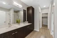 Sugarmont Townhouse Bathroom View of Sugarmont's Two Bedroom Townhome Showing Double Sinks, White Countertops, Wood Cabinets, and a Walk-In Closet