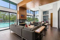 Clubroom with Pool Views View of Sugarmont Clubroom Showing Wood Lining, Grey Couch and Tall Glass Windows Showing A Pool View