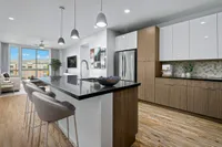 Open Concept Layouts View of Kitchen, Showing Kitchen Island, Overhead Lights, and Plank-Wood Flooring at Sugarmont Apartments