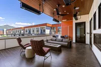 Sky Lounge Balcony Luxurious sky lounge balcony at Sugarmont Apartments and Townhomes featuring contemporary seating, elegant wood paneling, and breathtaking Wasatch mountain views.