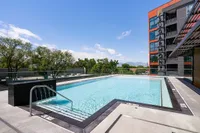 Resort-Style Swimming Pool Elegant rooftop swimming pool at Sugarmont Apartments with scenic mountain views and modern building architecture in Sugar House, Utah.