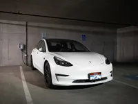 EV Charging Station Sleek electric car parked in a modern garage at Sugarmont Apartments and Townhomes with convenient charging station, highlighting eco-friendly urban living.